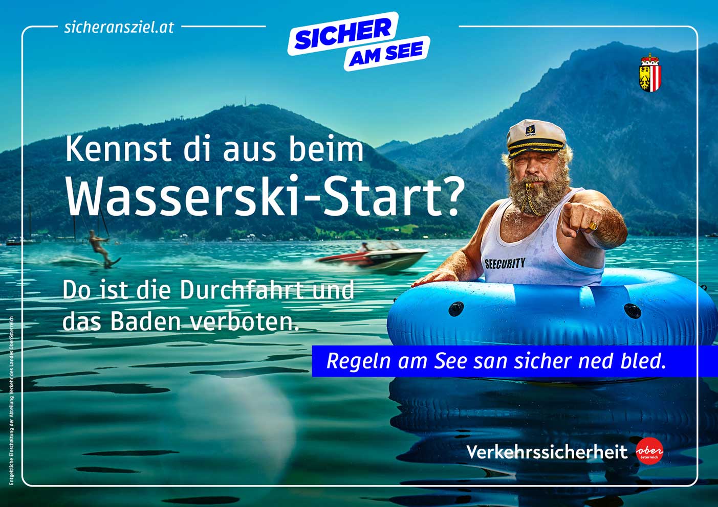 Seecurity Joe ist in einem blauen Schwimmreifen und pfeift mit einer goldenen Trillerpfeife, weil ein Motorbootfahrer viel zu schnell am Traunsee unterwegs ist. Im Hintergrund ist der Traunstein zu sehen.